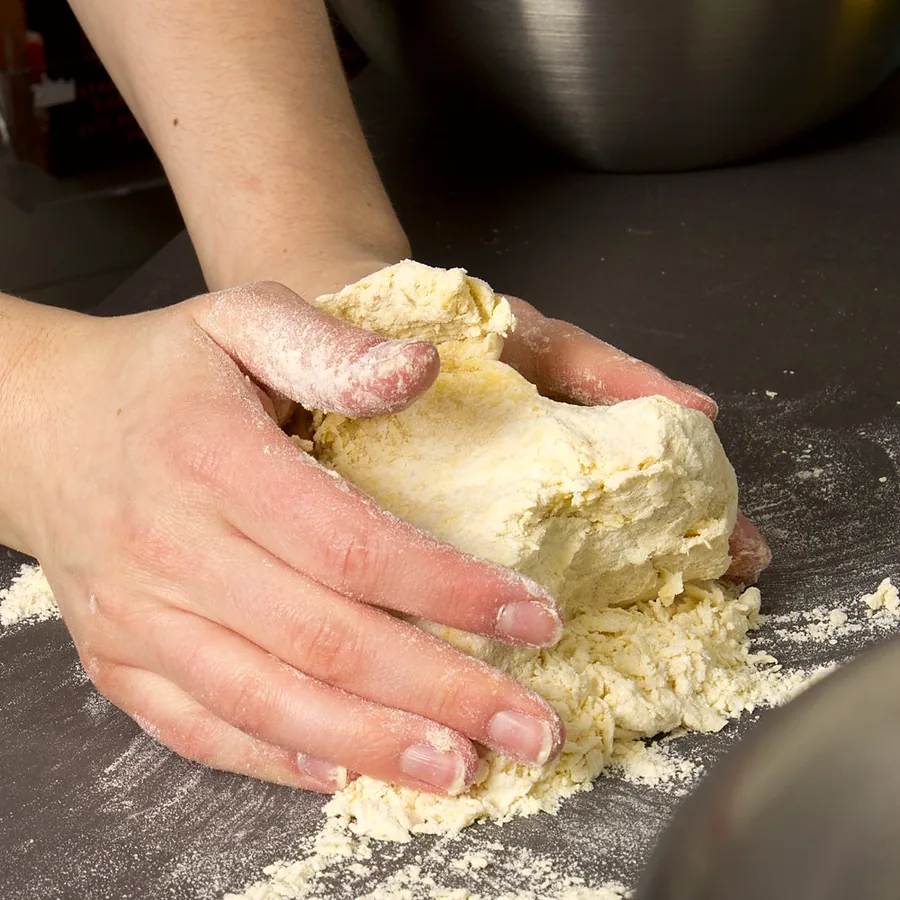 Hands preparing ingredients on a kitchen counter
