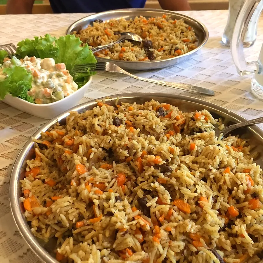 Serving bowls of rice and salad laid out for a gathering